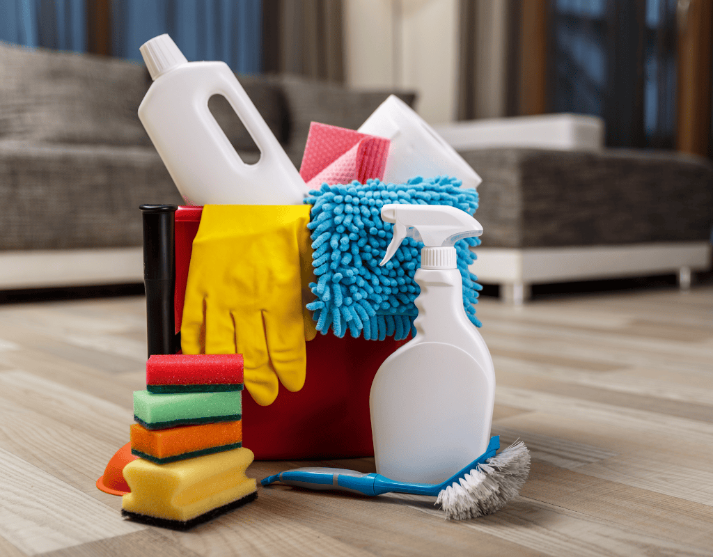 cleaning supplies bucket with spray bottles gloves and sponges on floor